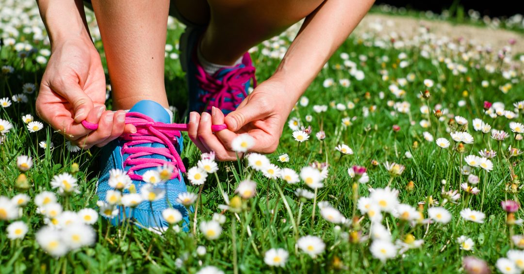 Female athlete getting ready for running in spring park. Fitness workout outdoor concept.